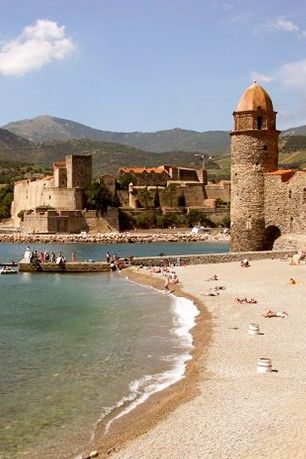 Collioure med sitt kastell och klocktorn med Pyrenéerna i bakgrunden.